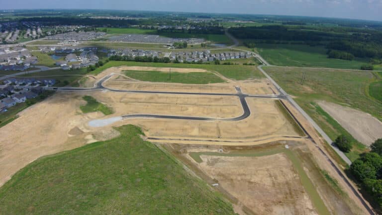 Lebanon, IN, residential development site with newly paved roads, cleared lots, and utility preparation for future housing.